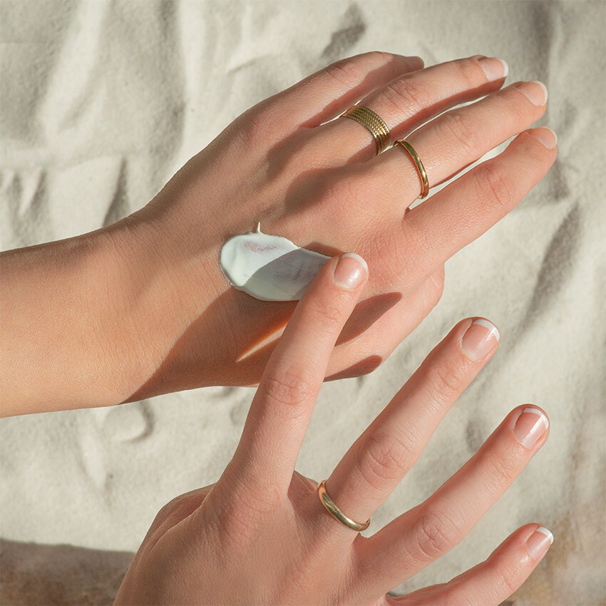 sonnencreme-gesicht-auf-hand-sand