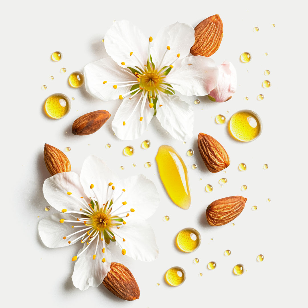 Öltropfen, Mandeln und weiße Blüten auf hellem Untergrund.