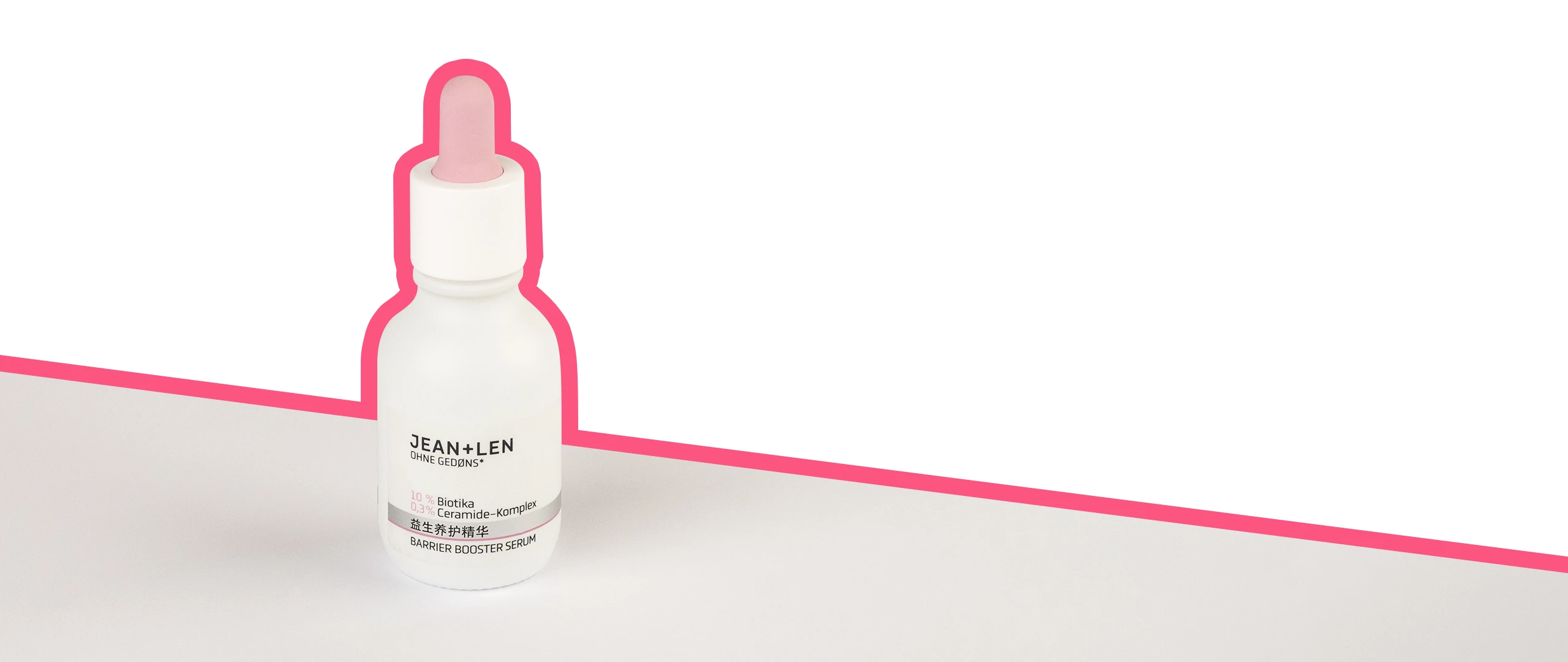 Barrier Booster Serum auf einem grauen Tisch umrandet von einer knallpinken Linie.