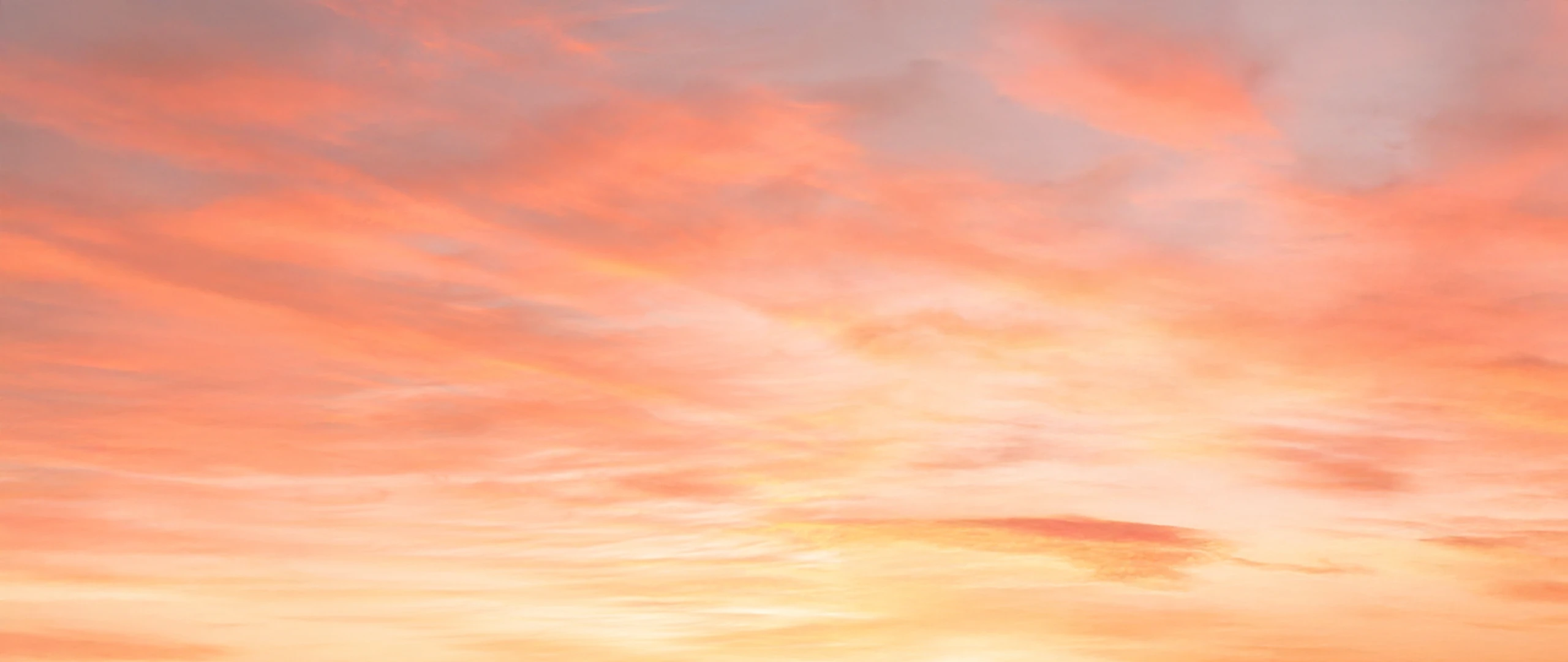 Ein mit zarten Wolken bedeckter Himmel bei Sonnenuntergang.