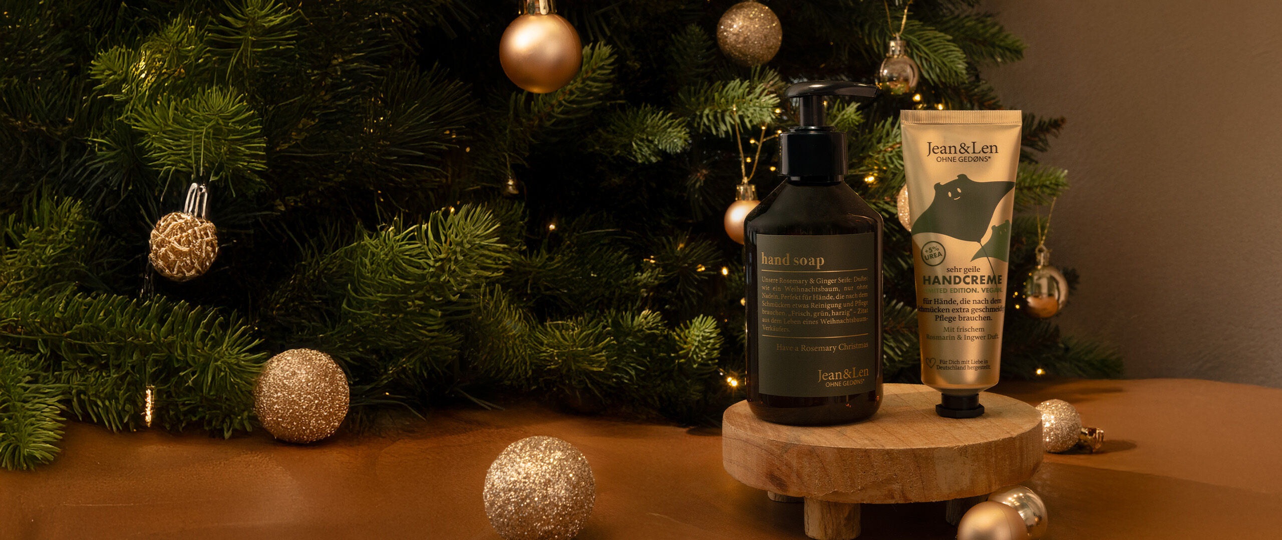 Eine Frau in weißem Strickpullover, zündet die Kerze Jean&Len Basil Mint & Eukalyputs an.