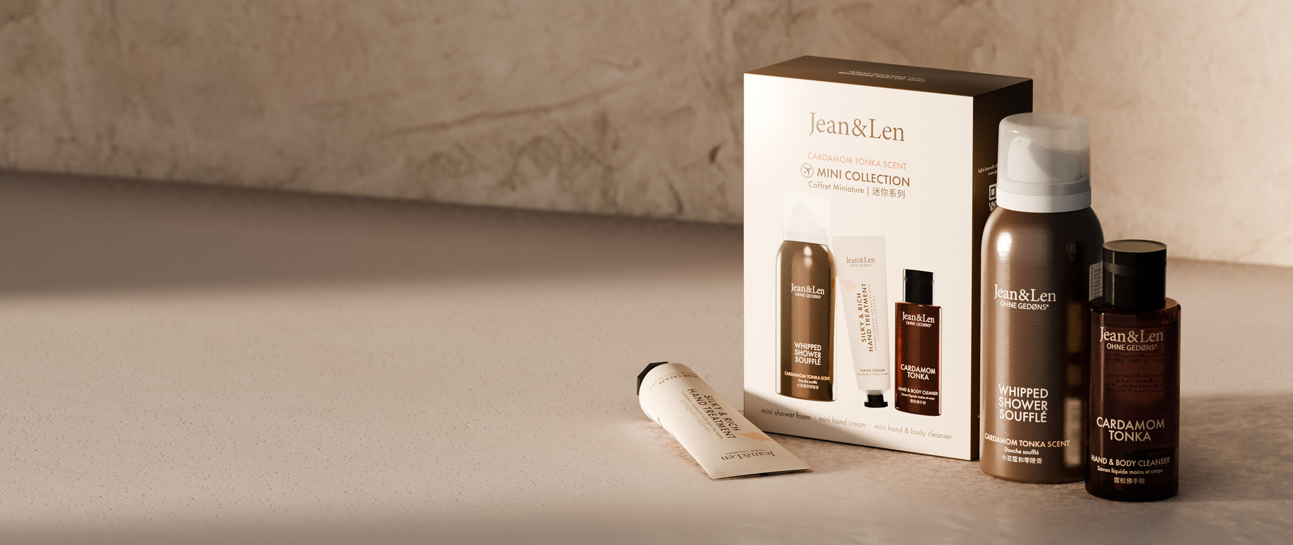 JeanLen Geschenksets Mini Collection Cardamom Tonka mit Handcreme, Duschschaum und Hand Body Cleanser platziert auf natürlichem Stein.